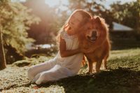 Liten flicka kramar sin hund